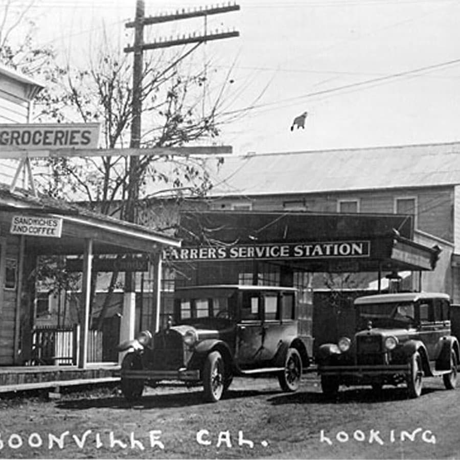 A black and white photograph of Farrer's Service Station in Boonville, California, circa 1920s, with vintage cars parked in front.